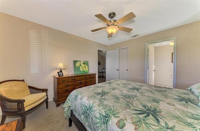 carpeted bedroom featuring ceiling fan, a closet, and a textured ceiling