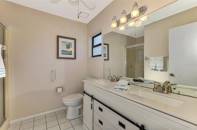 bathroom featuring tile patterned flooring, vanity, toilet, and a shower with door