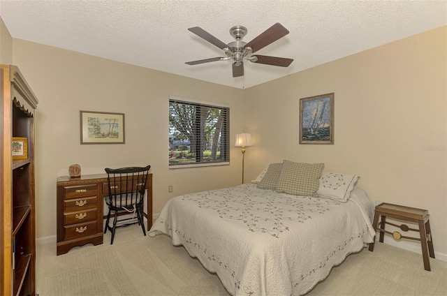 bedroom featuring ceiling fan, light colored carpet, and a textured ceiling