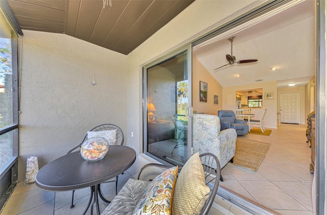 sunroom with ceiling fan, wooden ceiling, and vaulted ceiling