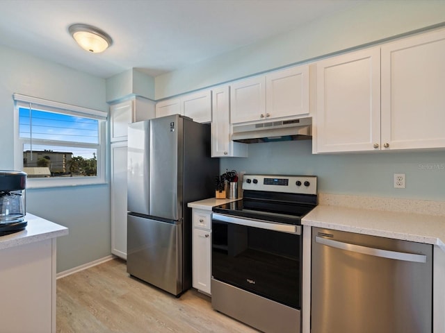 kitchen featuring white cabinets, light wood-type flooring, stainless steel appliances, and light stone counters