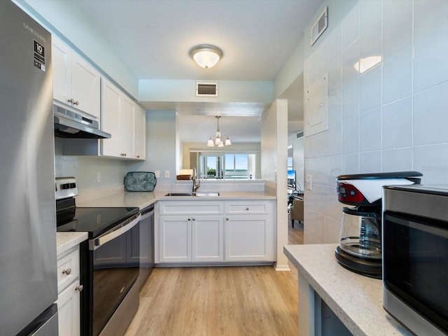 kitchen with sink, hanging light fixtures, appliances with stainless steel finishes, light hardwood / wood-style floors, and white cabinetry