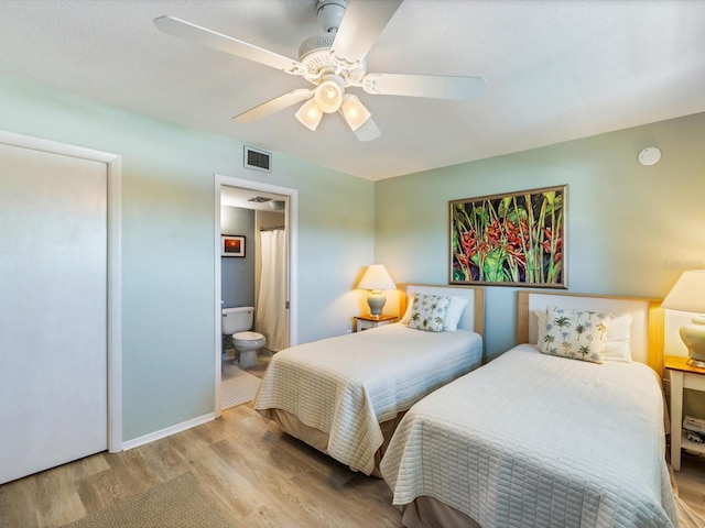 bedroom with ceiling fan, ensuite bathroom, and light wood-type flooring