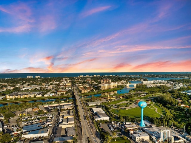 aerial view at dusk featuring a water view