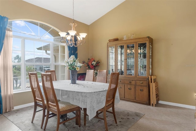 tiled dining space featuring lofted ceiling and a chandelier