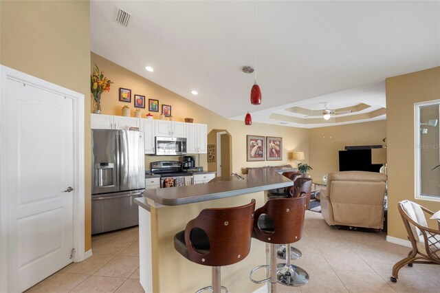 150 Marker Rd, Rotonda West, FL 33947 - kitchen featuring stainless steel appliances, light tile patterned flooring, dark countertops, a kitchen bar, and a ceiling fan