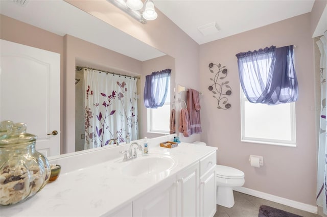 bathroom with tile patterned floors, plenty of natural light, vanity, and toilet