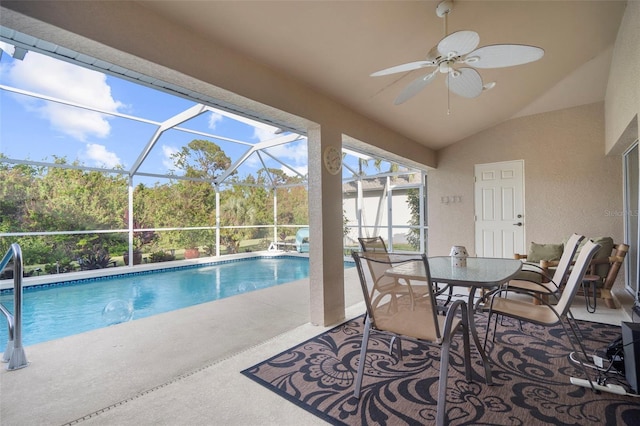 view of swimming pool with ceiling fan, a patio, and glass enclosure