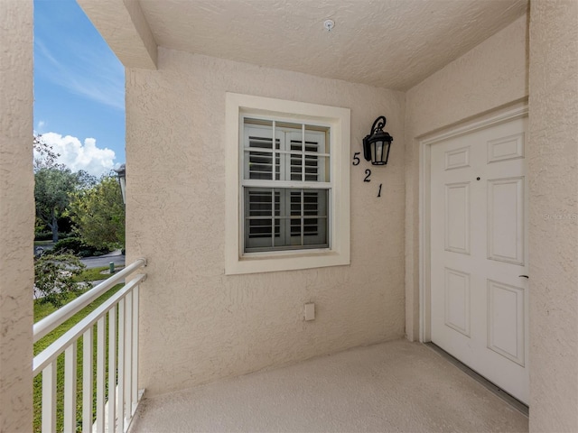 view of exterior entry with a balcony