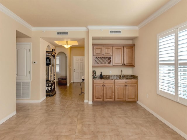 bar featuring light tile patterned floors, dark stone counters, crown molding, and sink