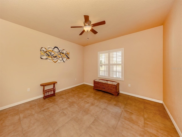 unfurnished room with ceiling fan and a textured ceiling