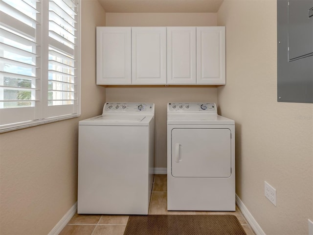 laundry room with cabinets, light tile patterned floors, washing machine and dryer, and electric panel