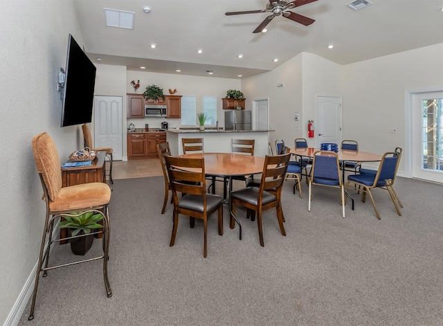 dining room with light carpet, ceiling fan, and sink