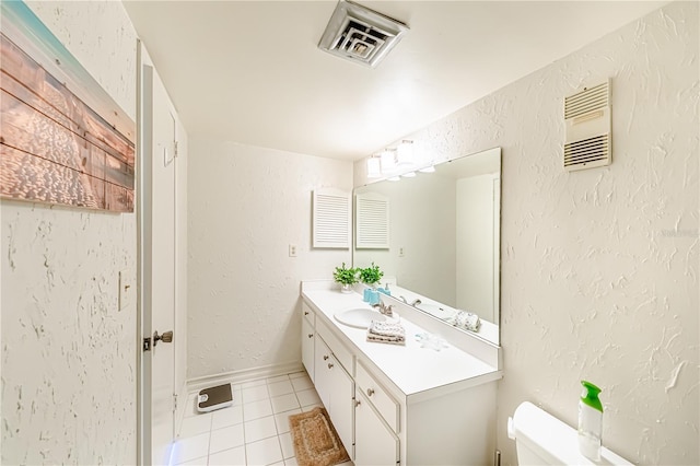 bathroom with toilet, vanity, and tile patterned floors