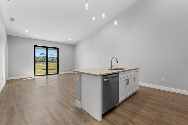 kitchen with sink, light stone counters, white cabinetry, dishwasher, and a kitchen island with sink