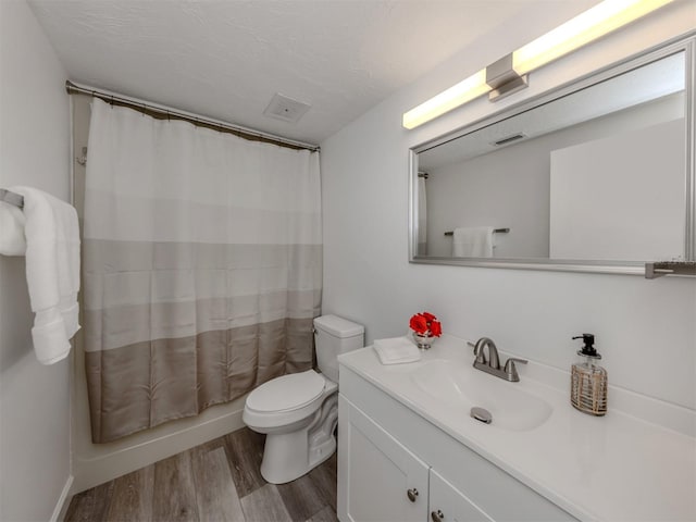 full bathroom with hardwood / wood-style floors, vanity, toilet, a textured ceiling, and shower / tub combo