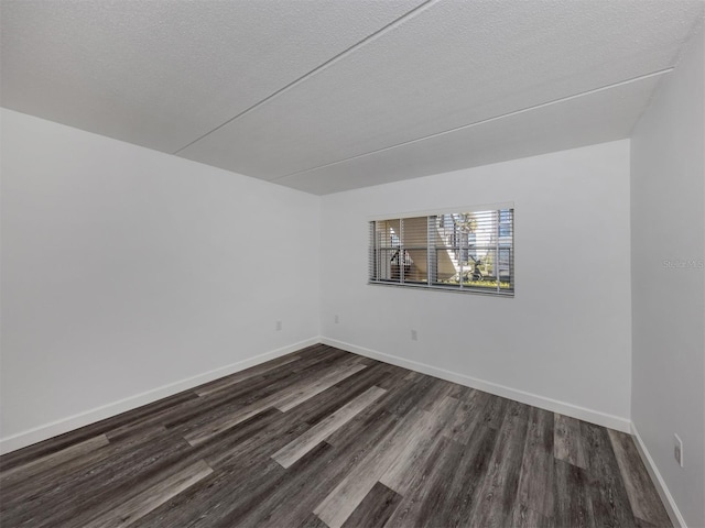 empty room featuring dark hardwood / wood-style floors and a textured ceiling