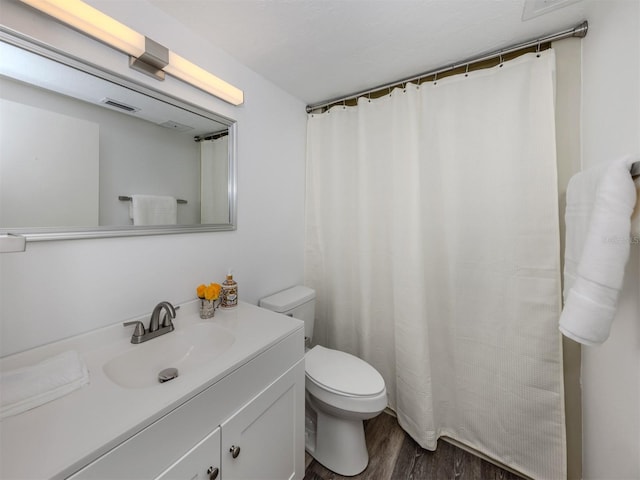 bathroom featuring vanity, wood-type flooring, and toilet