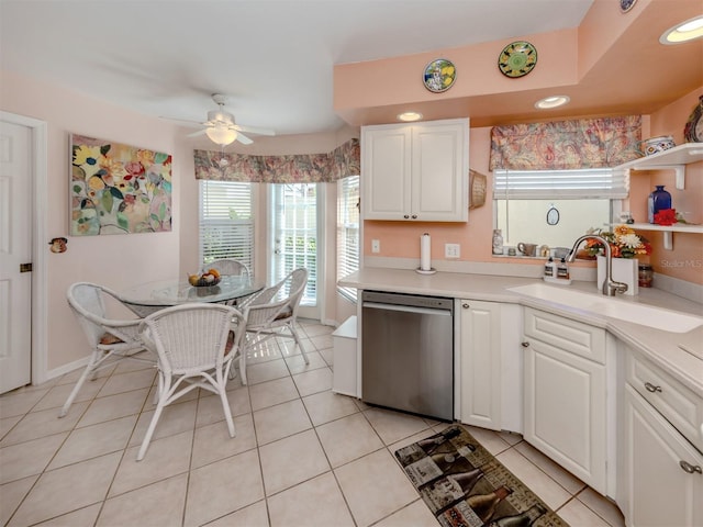 kitchen featuring dishwasher, sink, ceiling fan, light tile patterned floors, and white cabinetry