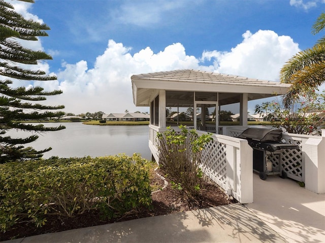 view of patio / terrace with a water view and a grill