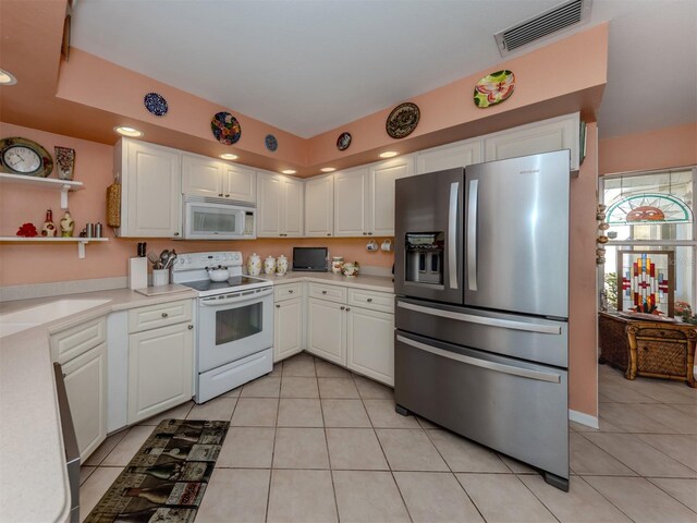 kitchen with white cabinets, white appliances, and light tile patterned floors