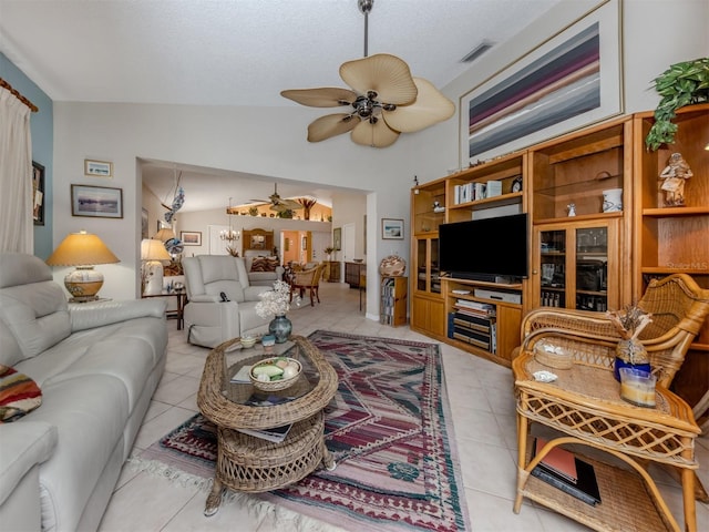 tiled living room with a textured ceiling, ceiling fan, and lofted ceiling