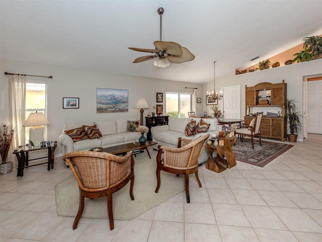 tiled living room with a wealth of natural light, ceiling fan with notable chandelier, and vaulted ceiling