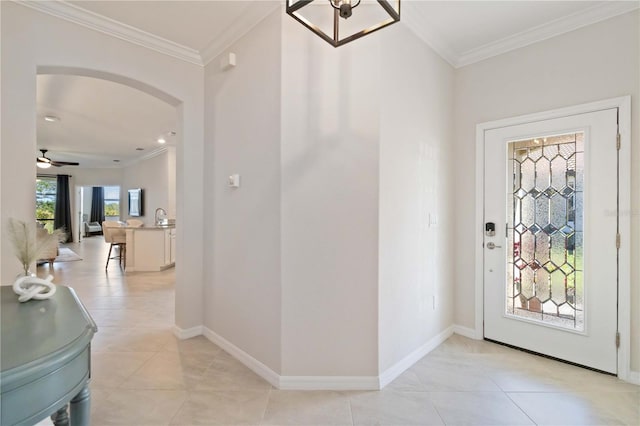 tiled entryway featuring ceiling fan and crown molding