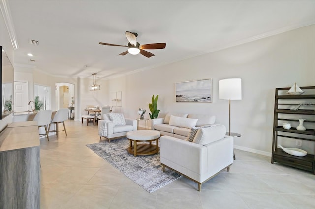 living room with light tile patterned floors, ceiling fan, ornamental molding, and sink