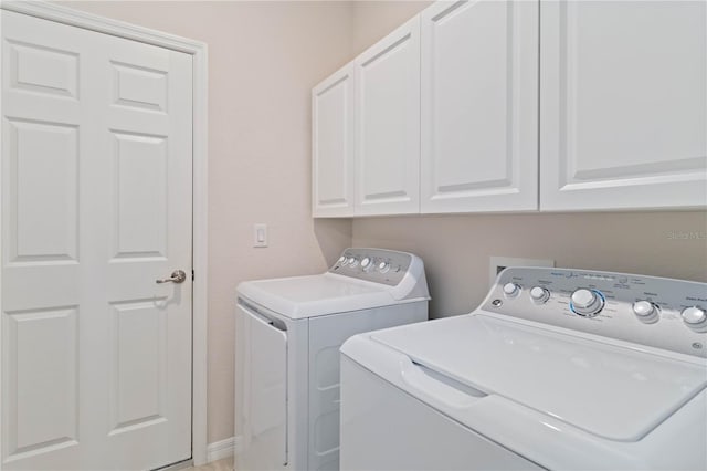 washroom featuring cabinets and separate washer and dryer