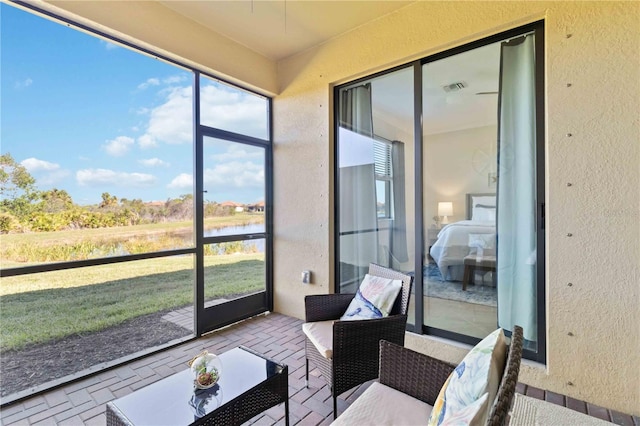 sunroom / solarium featuring a water view