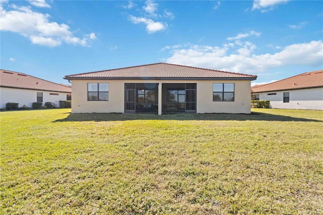 rear view of property with a sunroom and a yard