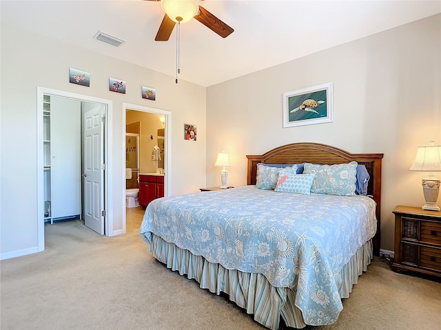 carpeted bedroom with ceiling fan and ensuite bath