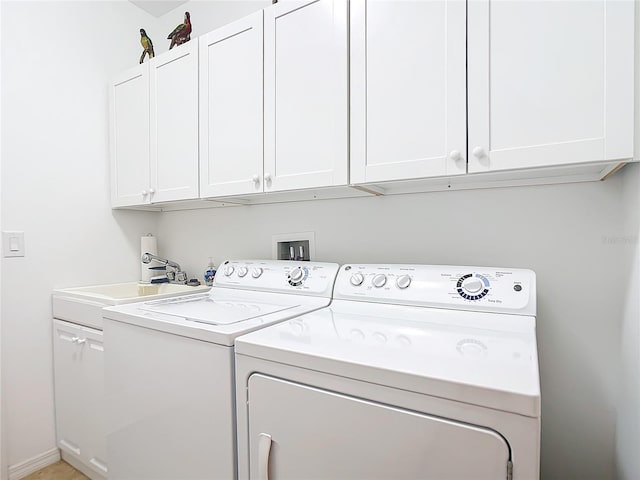 laundry area featuring cabinets, washing machine and dryer, and sink