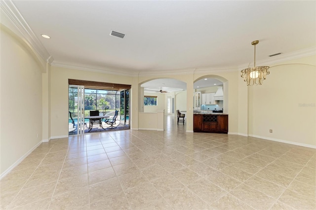 unfurnished room featuring visible vents, crown molding, arched walkways, and baseboards