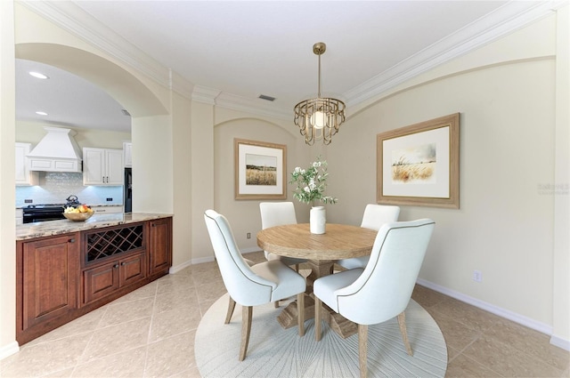 dining room with arched walkways, visible vents, crown molding, and baseboards