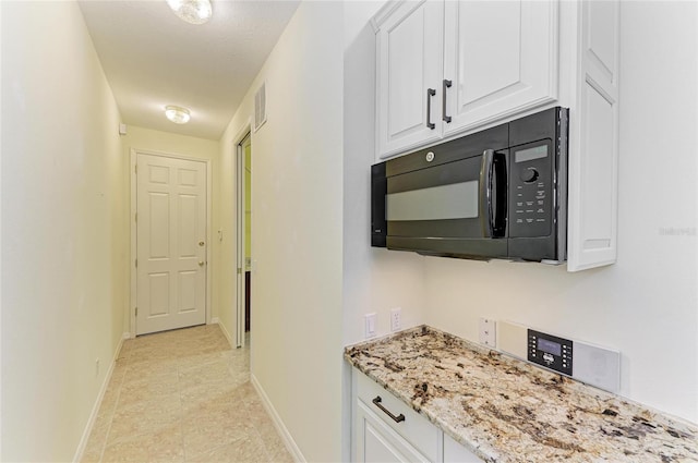 hallway featuring visible vents and baseboards