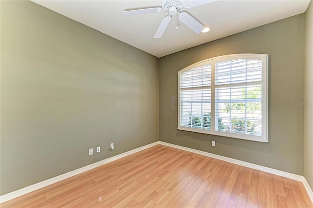 empty room featuring baseboards, ceiling fan, and light wood finished floors