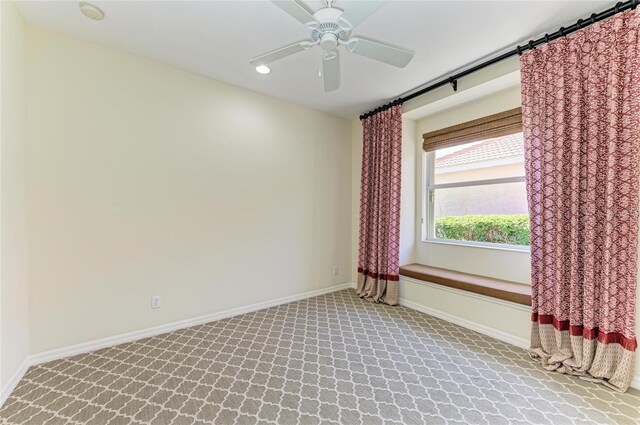 spare room with light carpet, ceiling fan, and baseboards