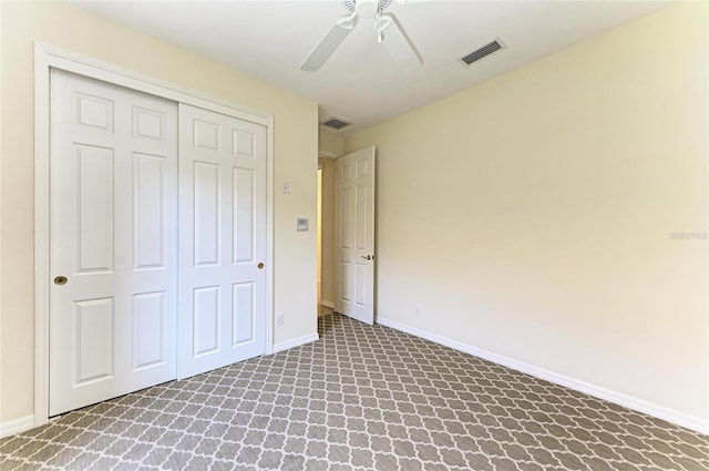 unfurnished bedroom featuring baseboards, visible vents, ceiling fan, carpet floors, and a closet