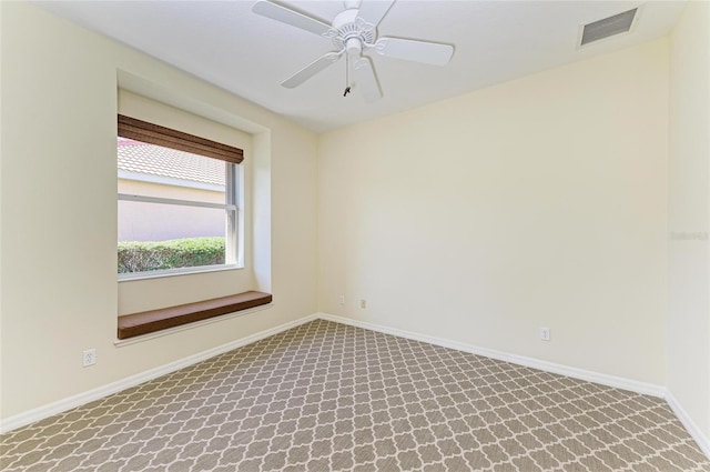 carpeted spare room with a ceiling fan, visible vents, and baseboards