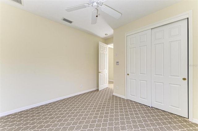 unfurnished bedroom with a closet, carpet, visible vents, and baseboards