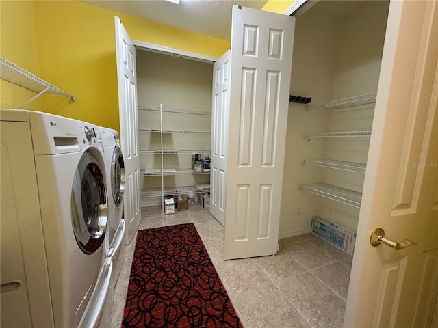 clothes washing area featuring washer and dryer, laundry area, and tile patterned floors