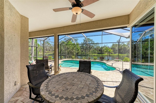 exterior space with outdoor dining area, glass enclosure, a patio, and ceiling fan