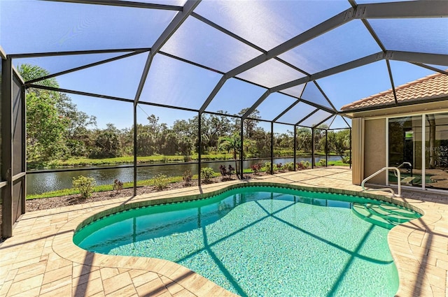 outdoor pool featuring a patio area, a water view, and a lanai