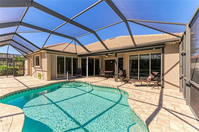 pool featuring glass enclosure, a patio, and ceiling fan