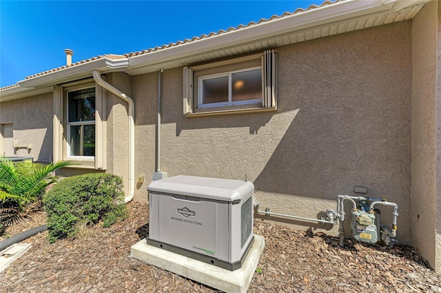 details with a power unit, gas meter, and stucco siding