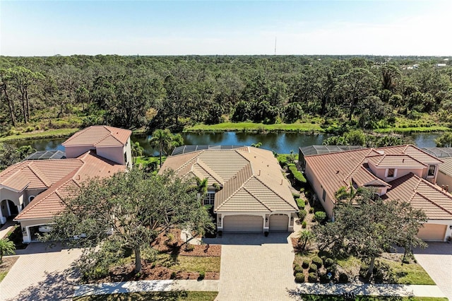 bird's eye view with a water view and a wooded view