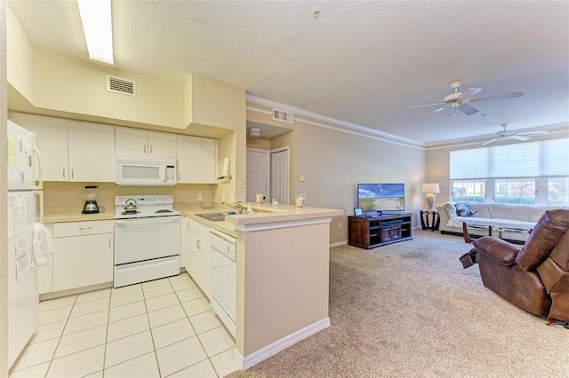 kitchen with kitchen peninsula, white appliances, light colored carpet, crown molding, and white cabinetry