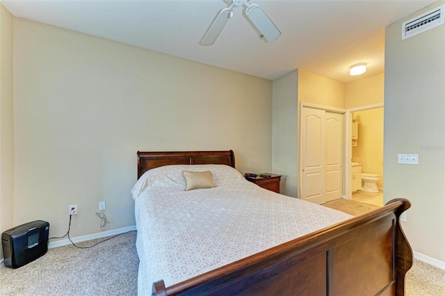 bedroom featuring ceiling fan, light colored carpet, and connected bathroom